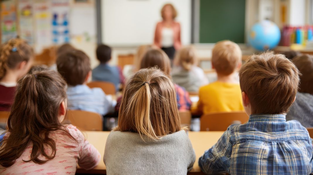 Education Elementary school learning and people concept group of school kids sitting and listening to teacher in classroom