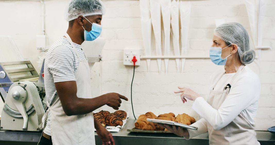 A state health inspector reviews a restaurant kitchen for sanitation compliance during routine food and health inspections in New Mexico.