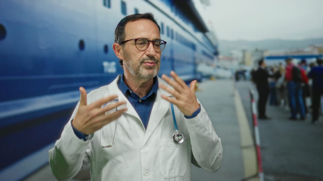 A health worker in protective gear inspects a cruise ship cabin for rodent activity, highlighting hantavirus prevention after a suspected outbreak.