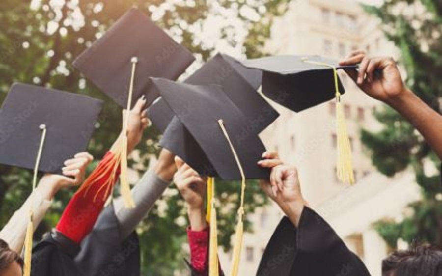 A group of graduates throwing graduation caps in the air