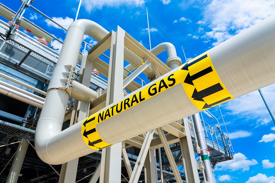 Natural gas pipeline with high pressure and direction sign at compressor station. Concept of energy transportation and distribution network