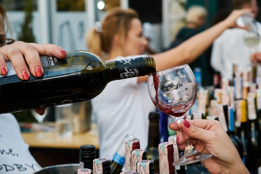 Female hand pours wine into a glass
