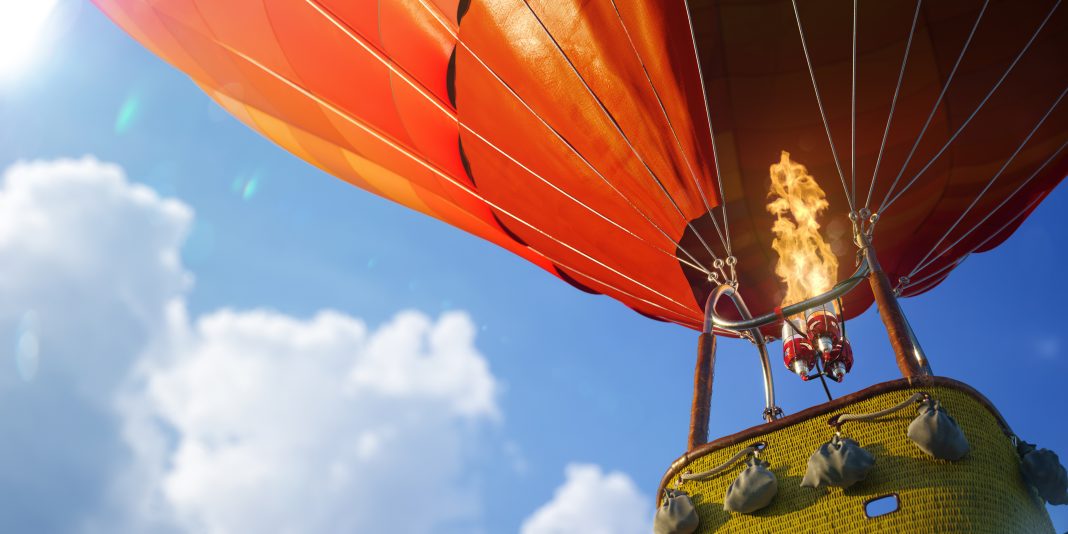 Colorful hot air balloons fly over Albuquerque during a ballooning event celebrating the city's aviation heritage.