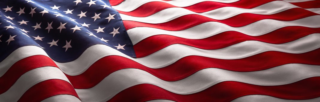 Rows of American flags are displayed during a ceremony honoring veterans, active-duty military personnel, first responders, and community heroes in New Mexico.