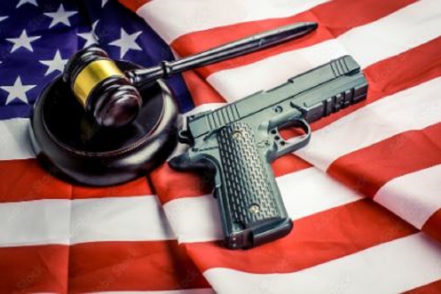 Wooden judge gavel and black color gun over USA flag