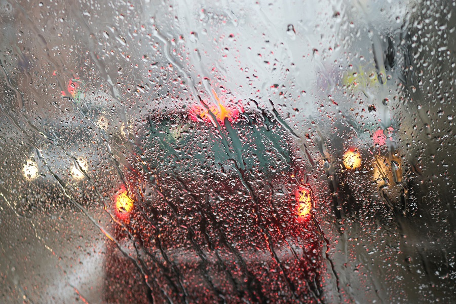 View from the car windscreen during rain and wet snow. Poor visibility while driving around the city. Snowy road.