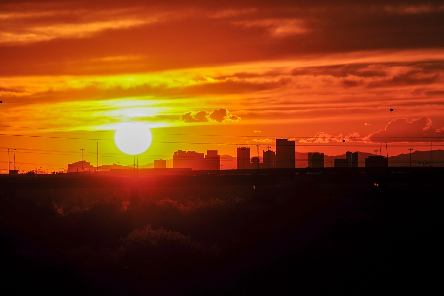 The intense sunlight of a sunset outlines the skyline