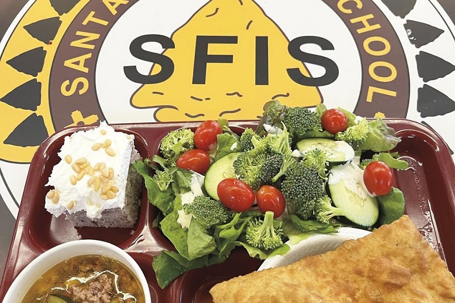 Santa Fe Indian School’s lunch tray of chicos stew simmered with tradition, a slice of blue corn cake alongside fry bread still warm, and a crisp salad pulled fresh from the school’s own bar.